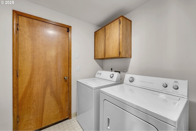 laundry area featuring separate washer and dryer, cabinet space, and light floors