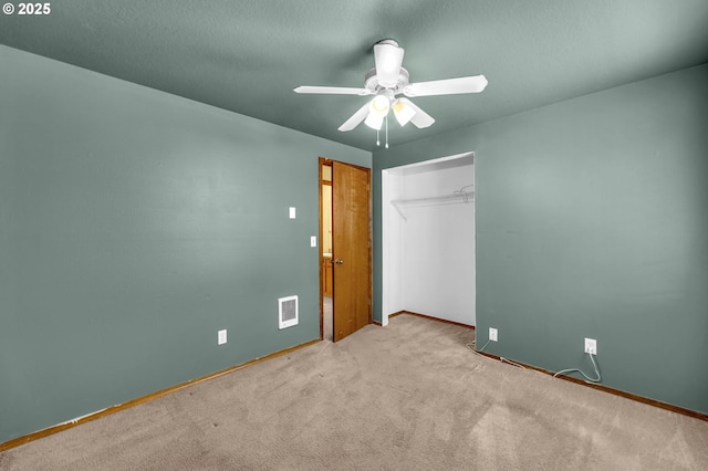 unfurnished bedroom featuring carpet flooring, a closet, ceiling fan, visible vents, and baseboards