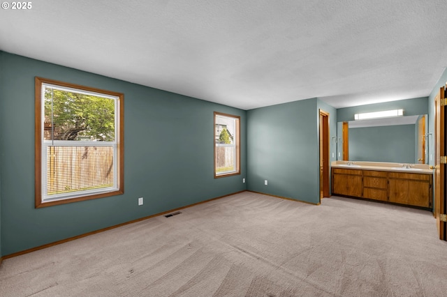 unfurnished bedroom with light colored carpet, visible vents, baseboards, and multiple windows