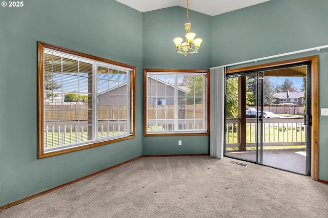 spare room with carpet flooring, visible vents, a chandelier, baseboards, and high vaulted ceiling