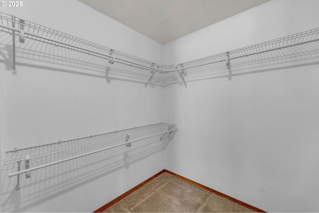 spacious closet with dark carpet