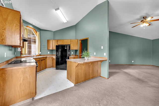 kitchen featuring black appliances, a ceiling fan, a peninsula, vaulted ceiling, and light countertops