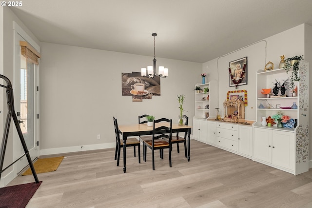 dining area with light wood-type flooring and an inviting chandelier