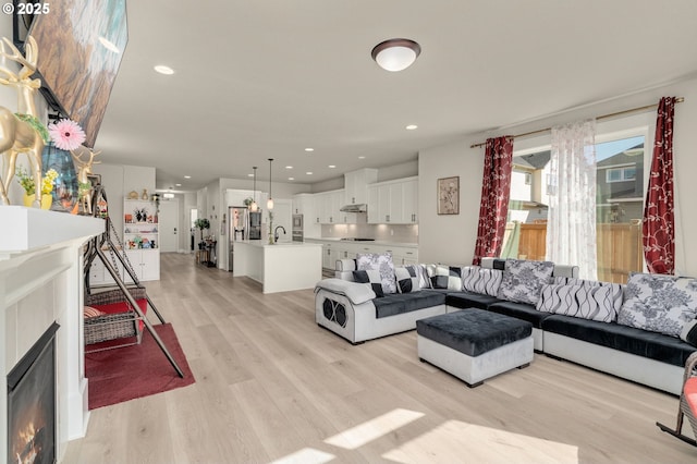 living room with sink and light wood-type flooring