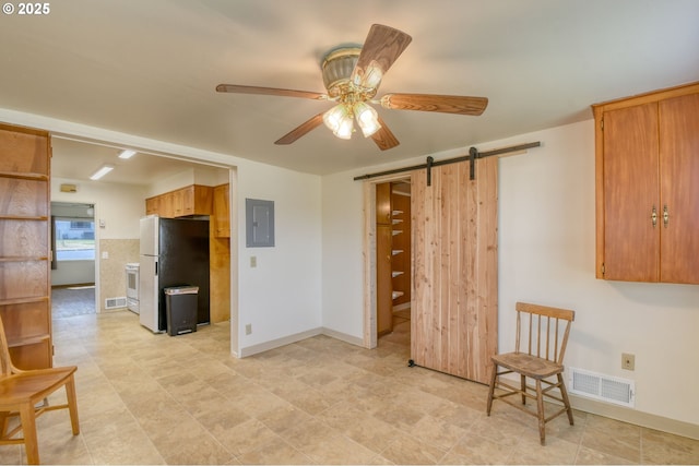 3103 SW Kirk Ave, Pendleton, OR 97801 - kitchen featuring freestanding refrigerator, electric panel, a barn door, a ceiling fan, and brown cabinets