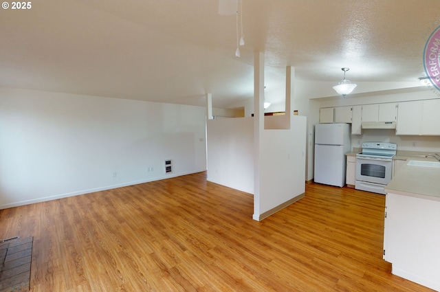 kitchen with vaulted ceiling, decorative light fixtures, sink, white cabinets, and white appliances