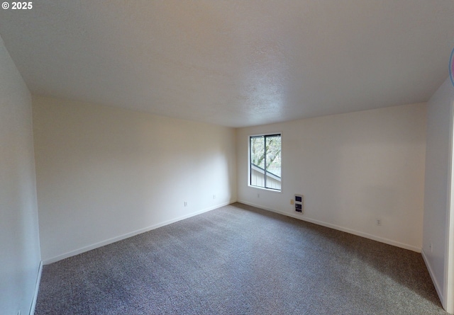 carpeted empty room with a textured ceiling