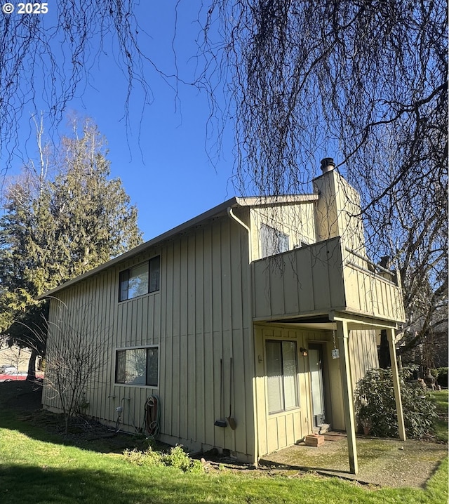 view of side of home featuring a lawn and a chimney