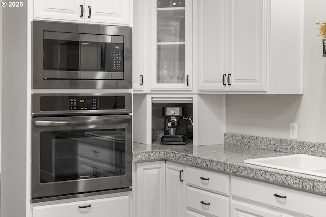 kitchen featuring appliances with stainless steel finishes, sink, and white cabinets