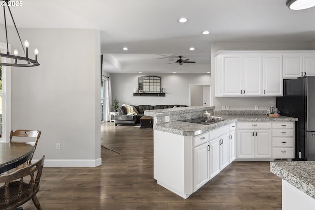 kitchen with white cabinetry, pendant lighting, dark wood-type flooring, and black appliances