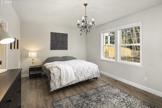 bedroom with dark hardwood / wood-style flooring and a notable chandelier