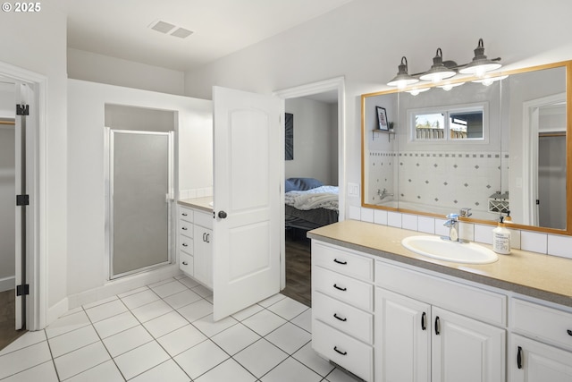 bathroom with tile patterned floors, vanity, and a shower with shower door