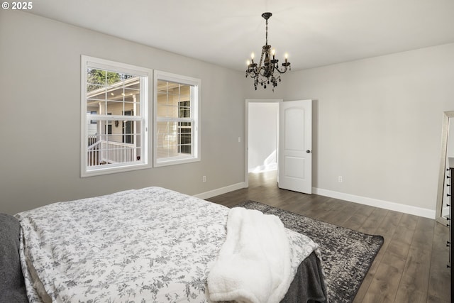 bedroom with dark hardwood / wood-style flooring and a chandelier