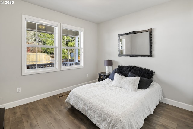 bedroom with dark hardwood / wood-style flooring