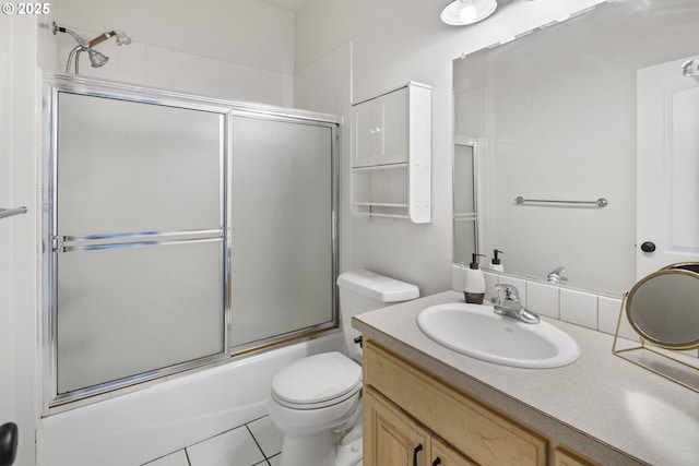 full bathroom featuring tile patterned flooring, vanity, bath / shower combo with glass door, and toilet