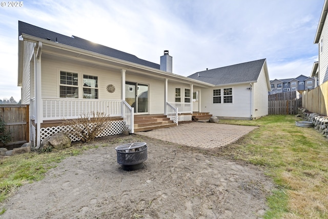 back of house with a patio, a fire pit, and a lawn