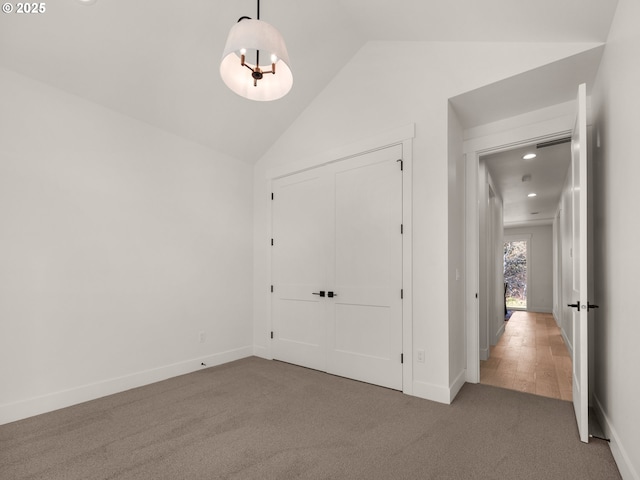 carpeted entrance foyer featuring lofted ceiling