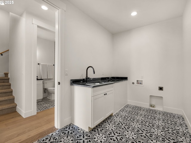 laundry room featuring washer hookup, hookup for an electric dryer, sink, and light wood-type flooring