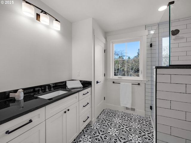 bathroom featuring vanity, tile patterned floors, and tiled shower