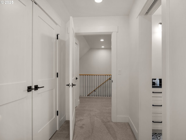 hall with vaulted ceiling and light colored carpet