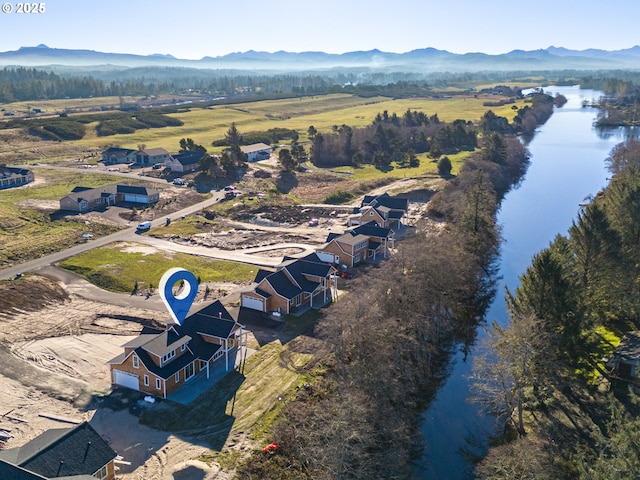 drone / aerial view featuring a water and mountain view