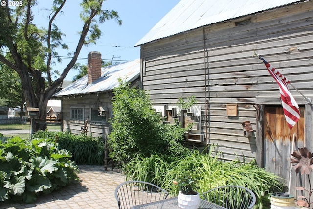 1407 9th St, Baker City, OR 97814 - view of home's exterior featuring metal roof, a chimney, and a patio