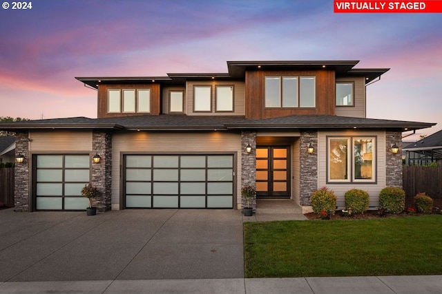 prairie-style home featuring a yard and a garage