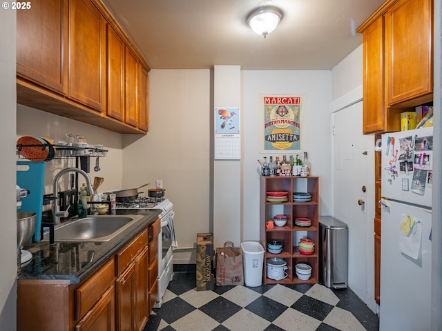 kitchen featuring white refrigerator, range with gas stovetop, and sink