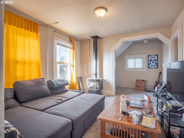 living room with a wood stove, a healthy amount of sunlight, and carpet