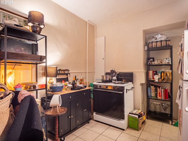 kitchen featuring light tile patterned floors and white range with gas stovetop