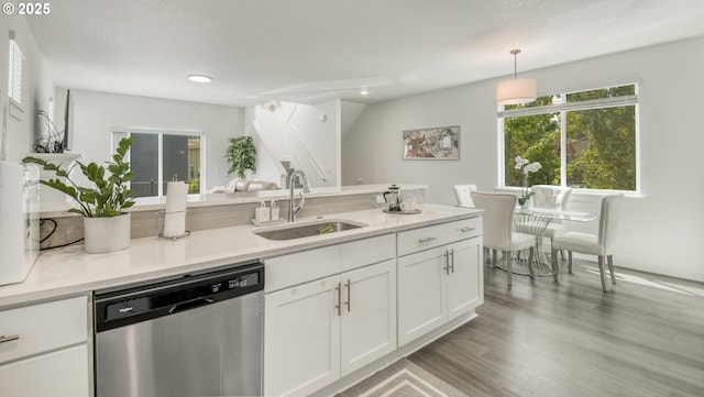 3037 SW Sherman Pl, Beaverton, OR 97003 - kitchen with stainless steel dishwasher, a sink, white cabinetry, light countertops, and light wood-style flooring