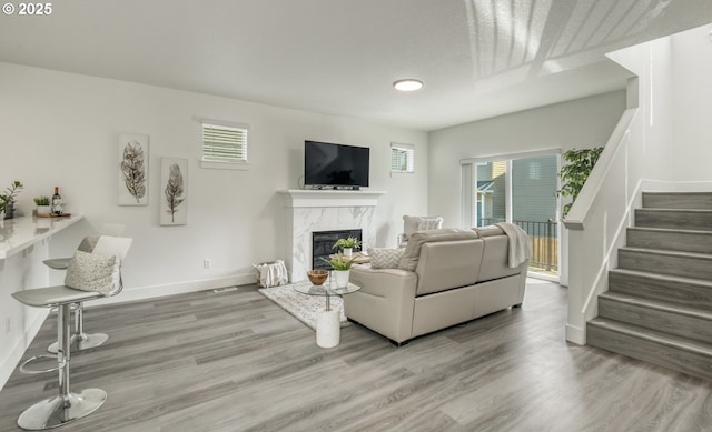 3037 SW Sherman Pl, Beaverton, OR 97003 - living area featuring a high end fireplace, stairway, wood finished floors, and baseboards