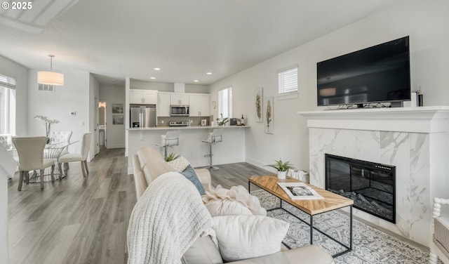 3037 SW Sherman Pl, Beaverton, OR 97003 - living area featuring light wood-style floors, recessed lighting, a fireplace, and baseboards