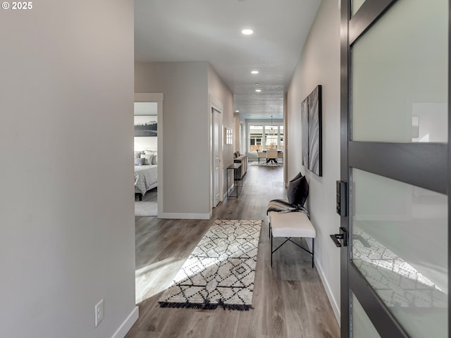 hallway featuring recessed lighting, baseboards, and wood finished floors