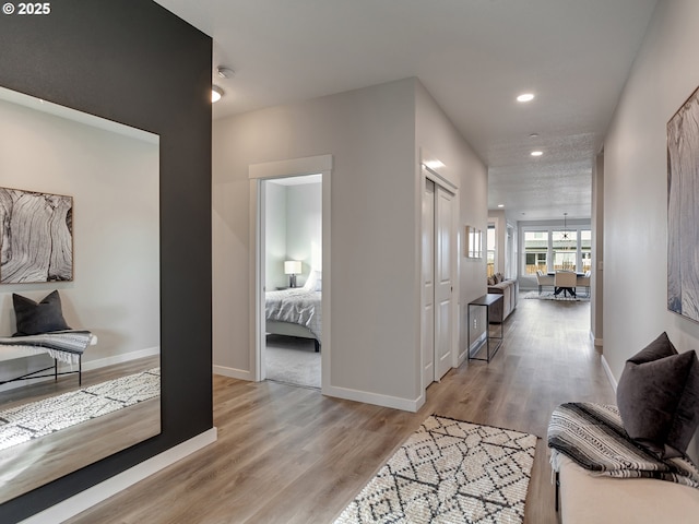 corridor featuring recessed lighting, wood finished floors, and baseboards