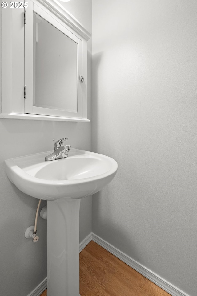 bathroom with baseboards and wood finished floors