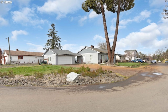 ranch-style house featuring a garage, a residential view, and fence