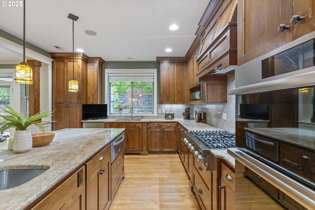 10137 SW Lancaster Rd, Portland, OR 97219 - kitchen with appliances with stainless steel finishes, light wood finished floors, decorative light fixtures, brown cabinetry, and a warming drawer
