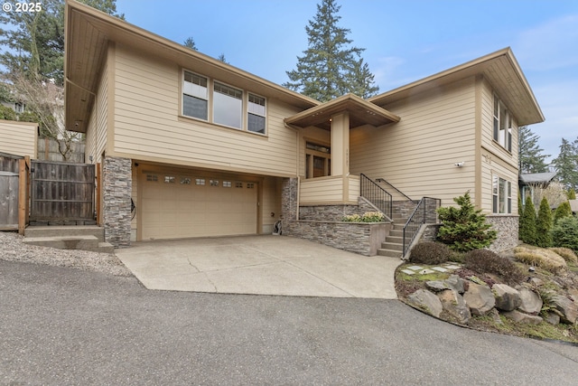 10137 SW Lancaster Rd, Portland, OR 97219 - view of front facade featuring stone siding, a garage, and concrete driveway
