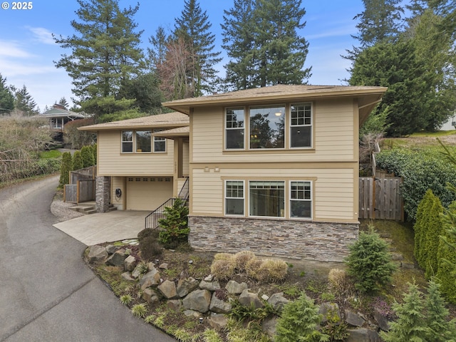 10137 SW Lancaster Rd, Portland, OR 97219 - view of front facade with asphalt driveway, stone siding, a garage, and stairs