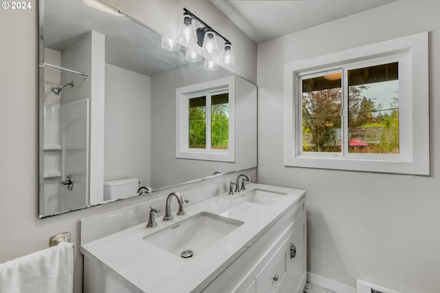 bathroom featuring walk in shower, vanity, a baseboard radiator, and toilet