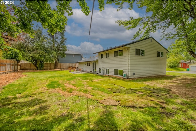 rear view of property featuring a lawn and a patio