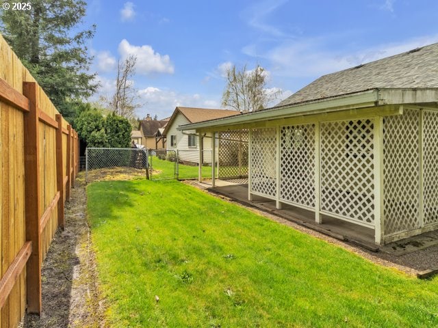 view of yard with a fenced backyard and a gate