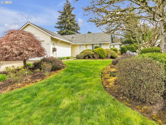 ranch-style home featuring an attached garage and a front yard