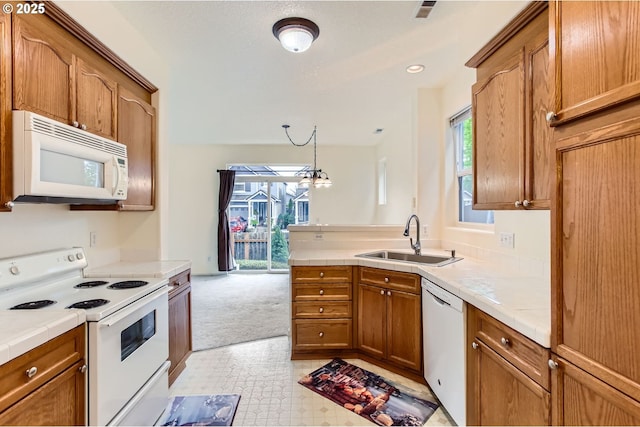 20372 SW Verona Ct, Beaverton, OR 97003 - kitchen with white appliances, brown cabinetry, a peninsula, tile countertops, and light colored carpet