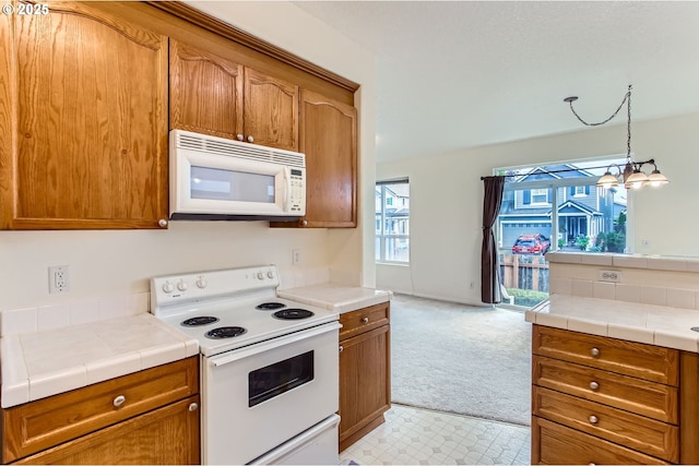 20372 SW Verona Ct, Beaverton, OR 97003 - kitchen featuring white appliances, brown cabinetry, light carpet, and pendant lighting