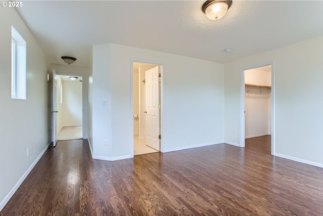 20372 SW Verona Ct, Beaverton, OR 97003 - unfurnished bedroom featuring dark wood-style floors, a walk in closet, ensuite bathroom, and a closet