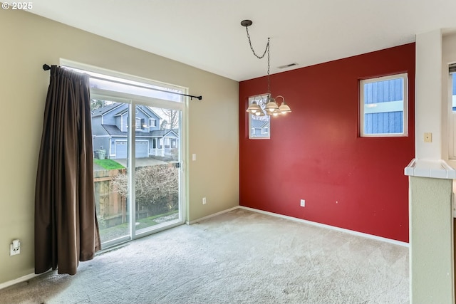 unfurnished dining area with baseboards, carpet flooring, and a notable chandelier