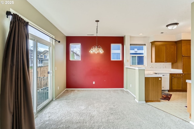 kitchen featuring white dishwasher, light carpet, light countertops, brown cabinets, and pendant lighting