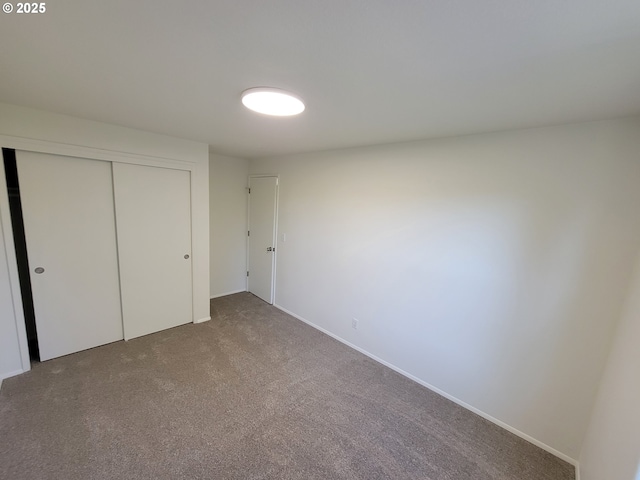 unfurnished bedroom featuring carpet floors and a closet